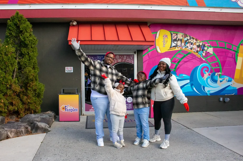 family in front of the funplex entrance in the winter