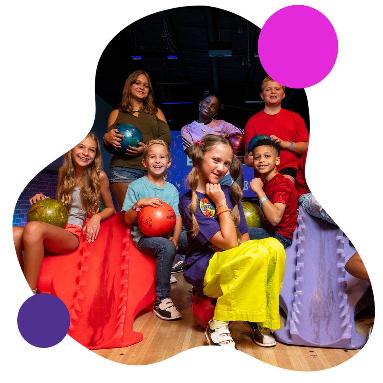 Image of kids smiling at a bowling alley